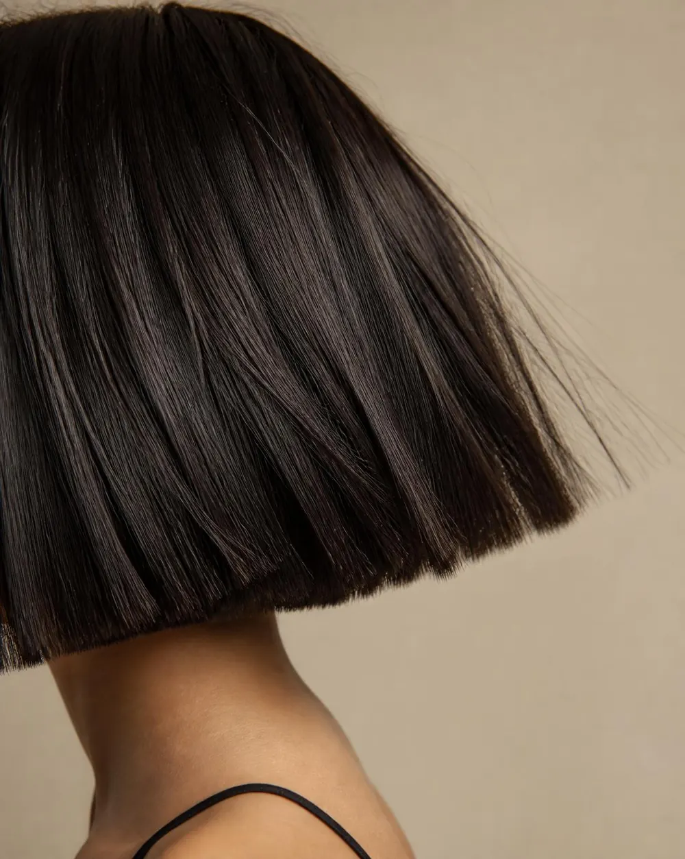 Corte reto com acabamento preciso, visto de perfil, em fundo bege